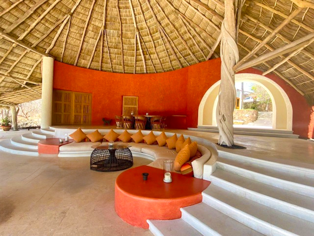 Palapa lounge with a coral banquette and terrace steps