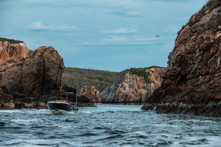 Boat arriving in a rocky cove on Chamela Bay