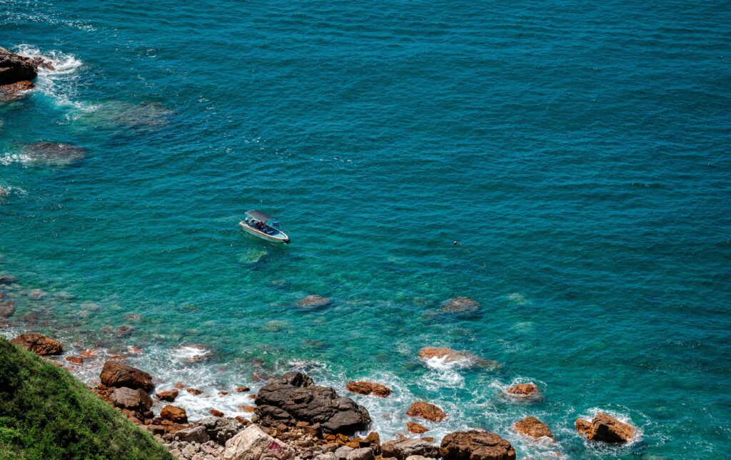 Boat on turquoise water off the rocky Costalegre coast