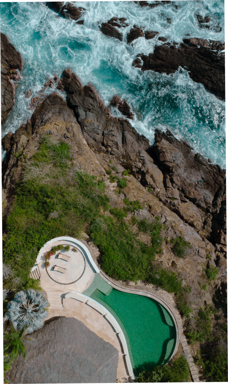 Aerial view of Casa Papelillo on its green cliff above the Pacific