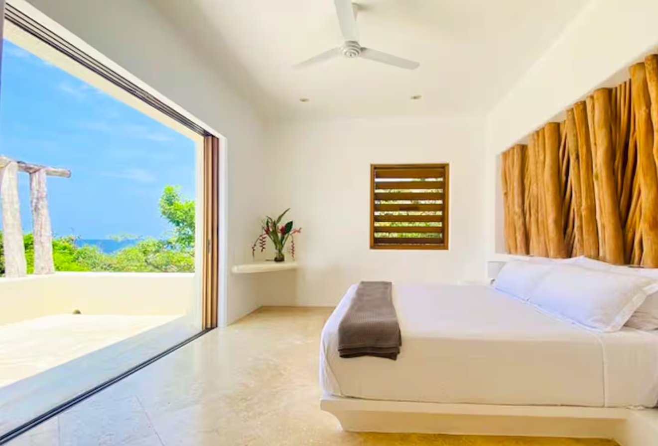 The Sun master suite with glass doors to the sea at Casa Papelillo